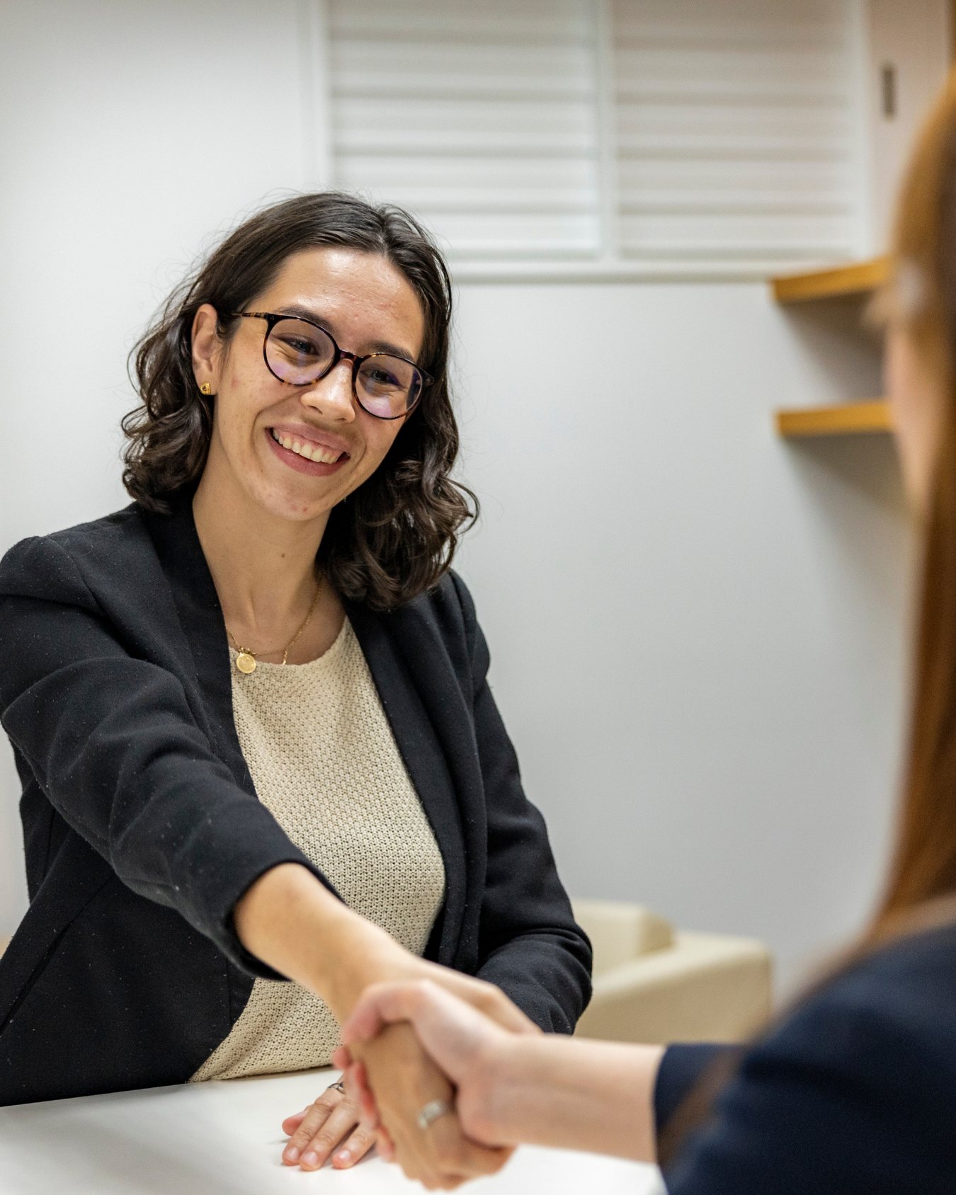Recrutadora cumprimentando uma candidata em entrevista
